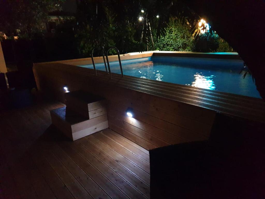 a swimming pool at night with a bench next to it at Barbara B&B in Fontane Bianche