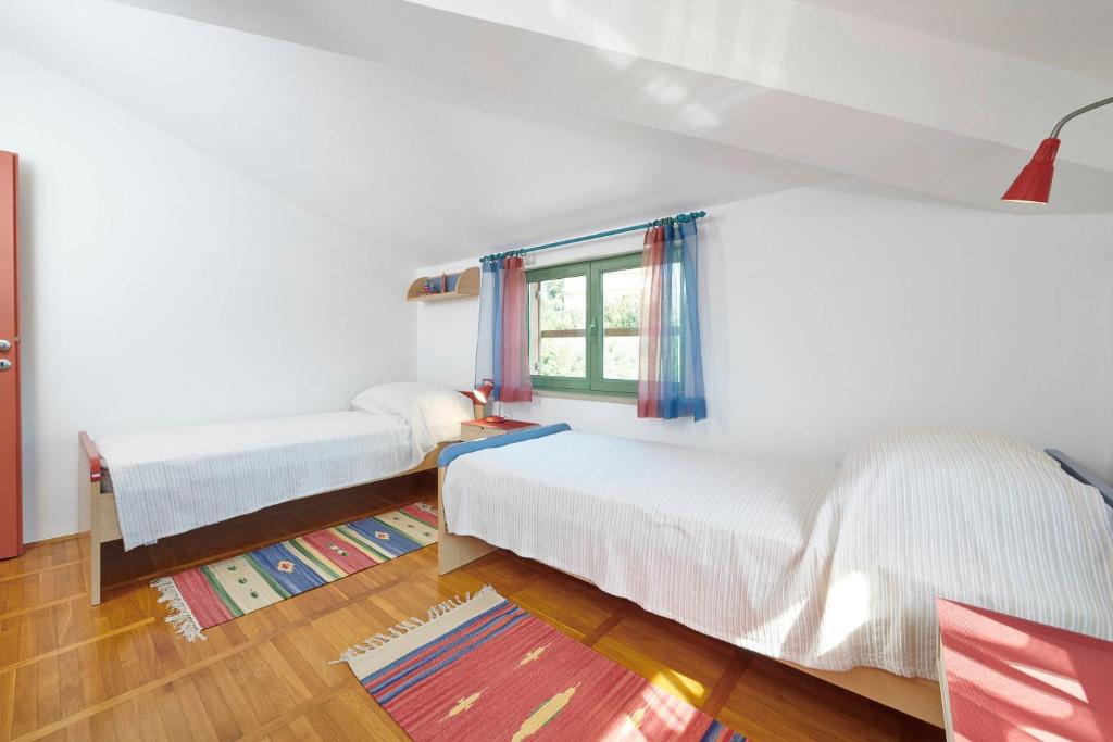 a bedroom with two beds and a window at Villa Giardina Apartments in Vinkuran