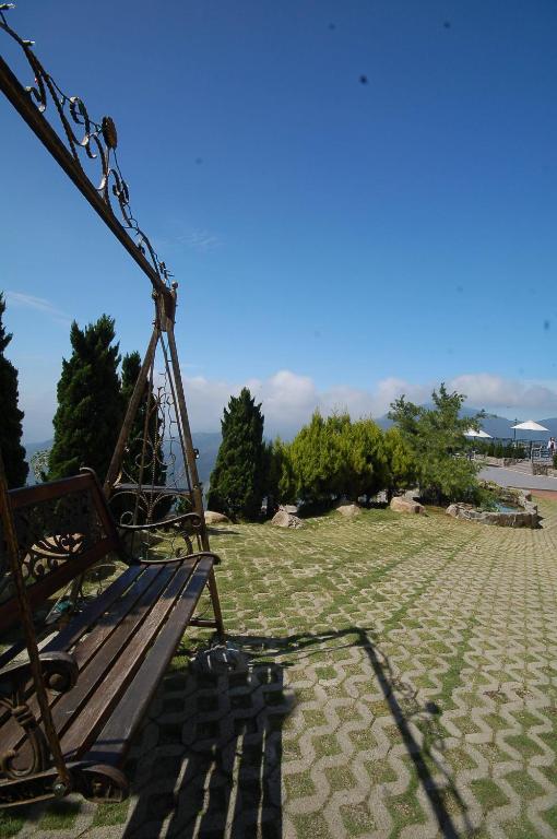 a park bench sitting on a grassy field with trees at Star Villa in Ren&#39;ai