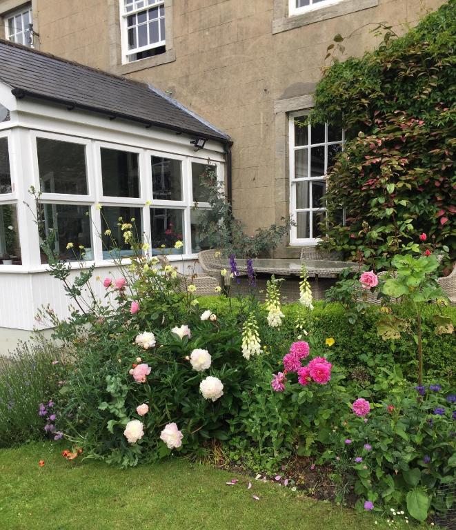 a garden of flowers in front of a house at The Old Manse in Lowick