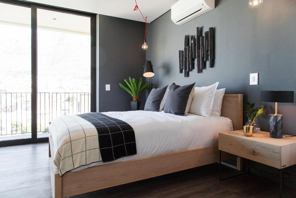 sypialnia z dużym łóżkiem i dużym oknem w obiekcie Wex 1 Apartments w Kapsztadzie