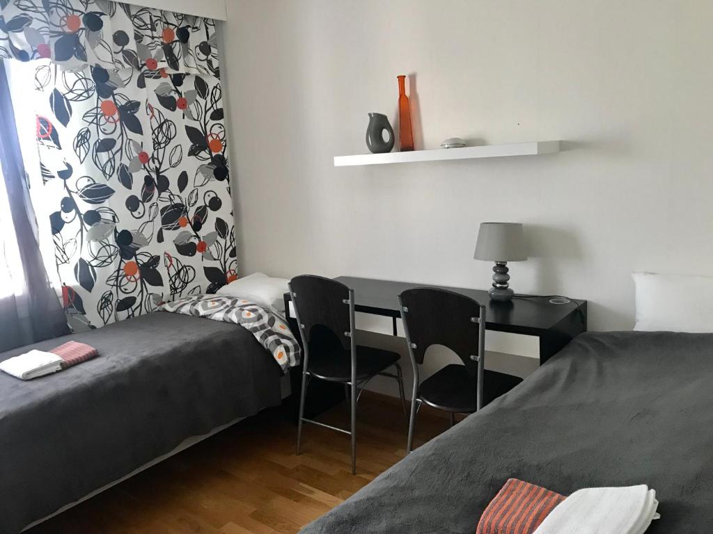 1 dormitorio con 1 cama y escritorio con sillas en PIKNIK - 2, en Tampere