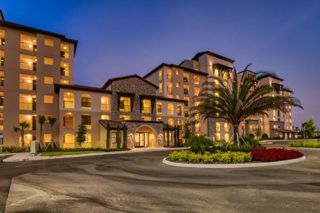 a building with a palm tree in front of it at Siena at Bella Collina in Montverde