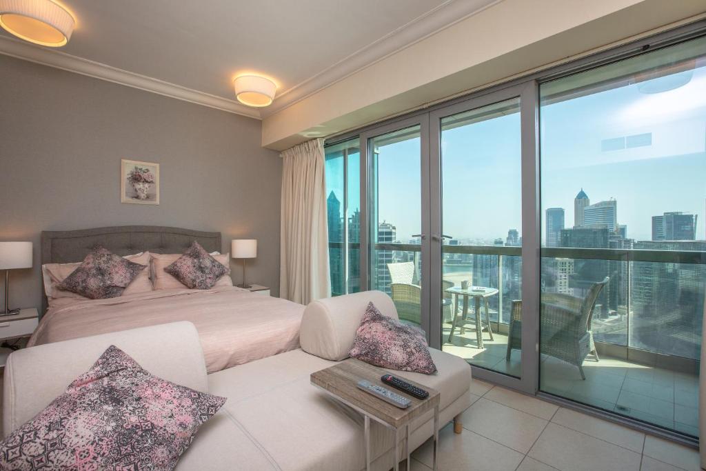 a bedroom with a bed and a couch and a balcony at Prime Retreats - Downtown Dubai in Dubai
