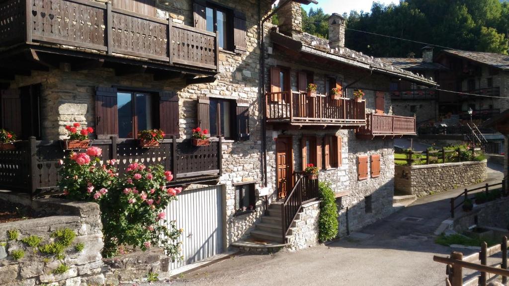 un groupe de bâtiments avec balcon et fleurs sur eux dans l'établissement La Meisoun de Lanta - cir n 0003, à Introd