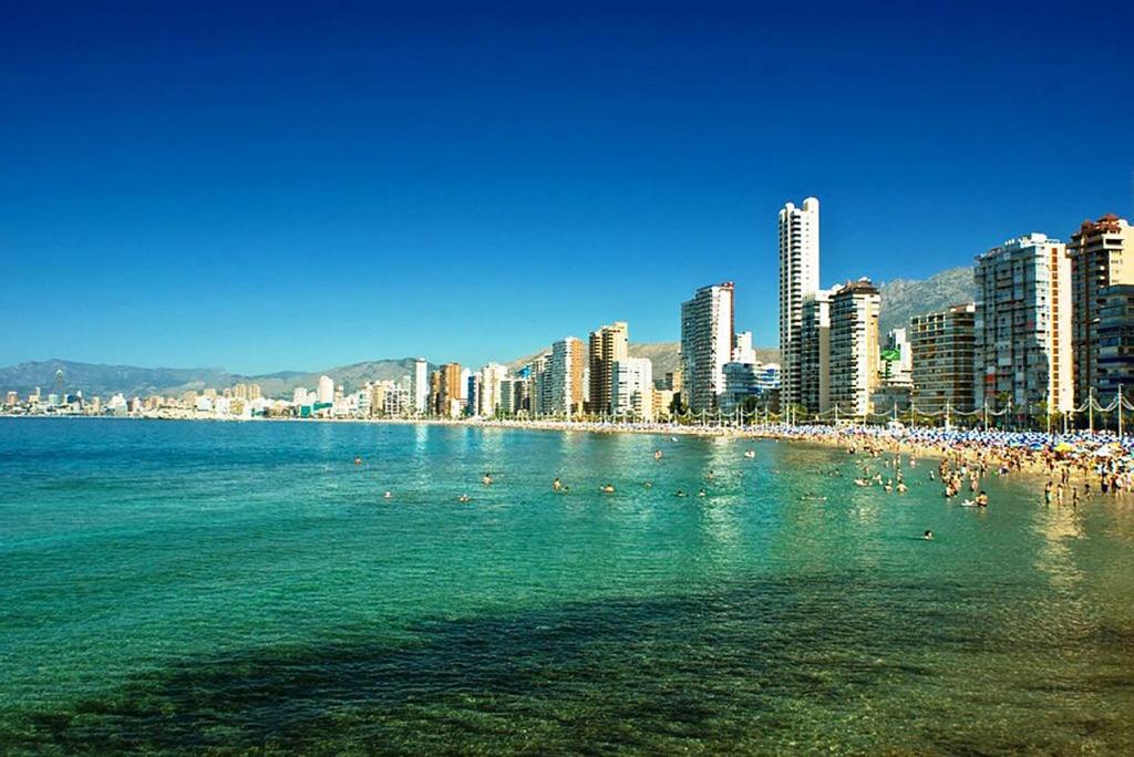 Une plage avec un tas de gens dans l'eau dans l'établissement TROPIC MAR Levante beach apartments, à Benidorm