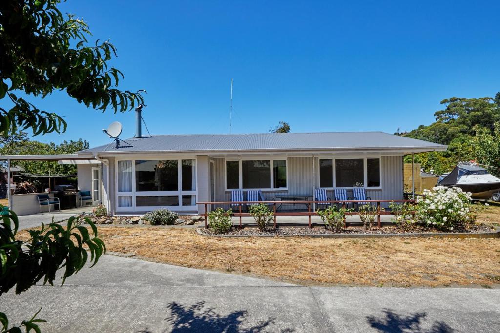 a house with blue chairs in front of it at Central, Affordable, Boat Parking - KK18865 in Kaikoura