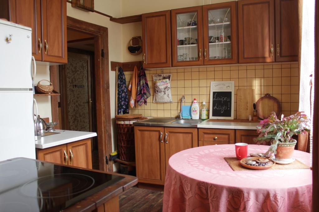 een keuken met een tafel met een roze tafelkleed bij Apartment Rumbas - 6 in Kuldīga