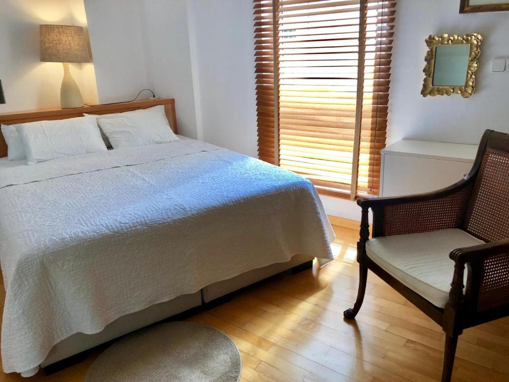 a bedroom with a bed and a chair and a window at Diana 16 in Denia