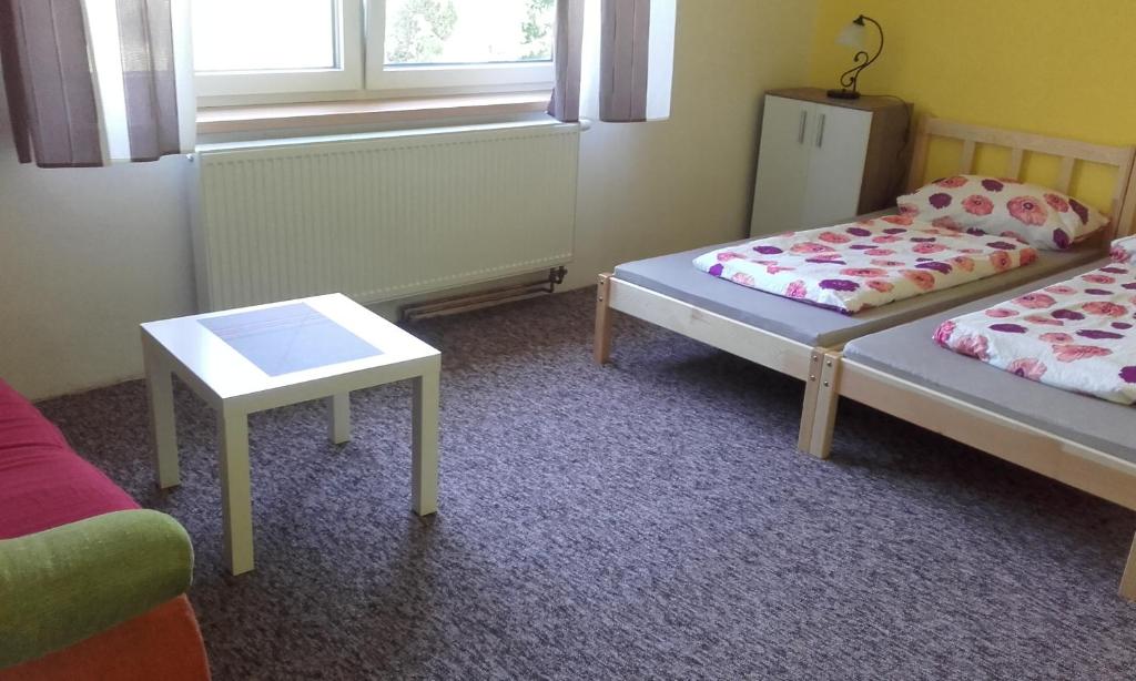 a room with two beds and a table at Holiday home Hájenka in Blažejovice