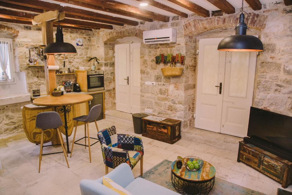 a living room with stone walls and a table and chairs at 5 minutes walk ART in Split
