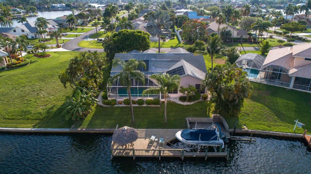 uma vista aérea de uma casa com uma doca na água em Hidden Harbor SW Cape- waterfront private home locally owned & managed, fair & honest pricing em Cape Coral