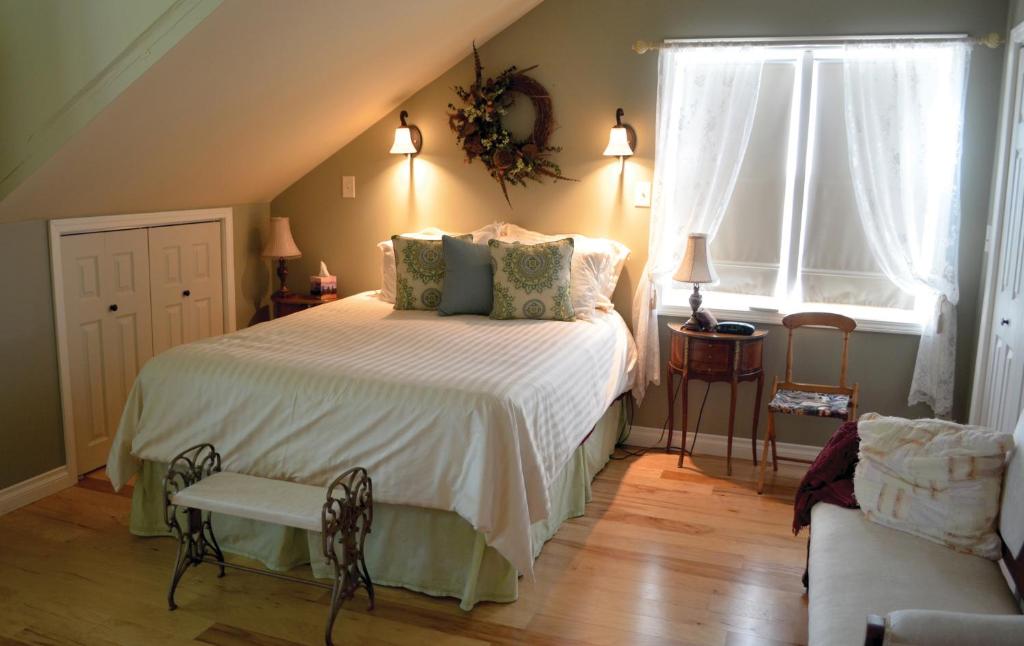 ein Schlafzimmer mit einem Bett, einem Stuhl und einem Fenster in der Unterkunft The Lace Curtain Cottage in Chadwicks