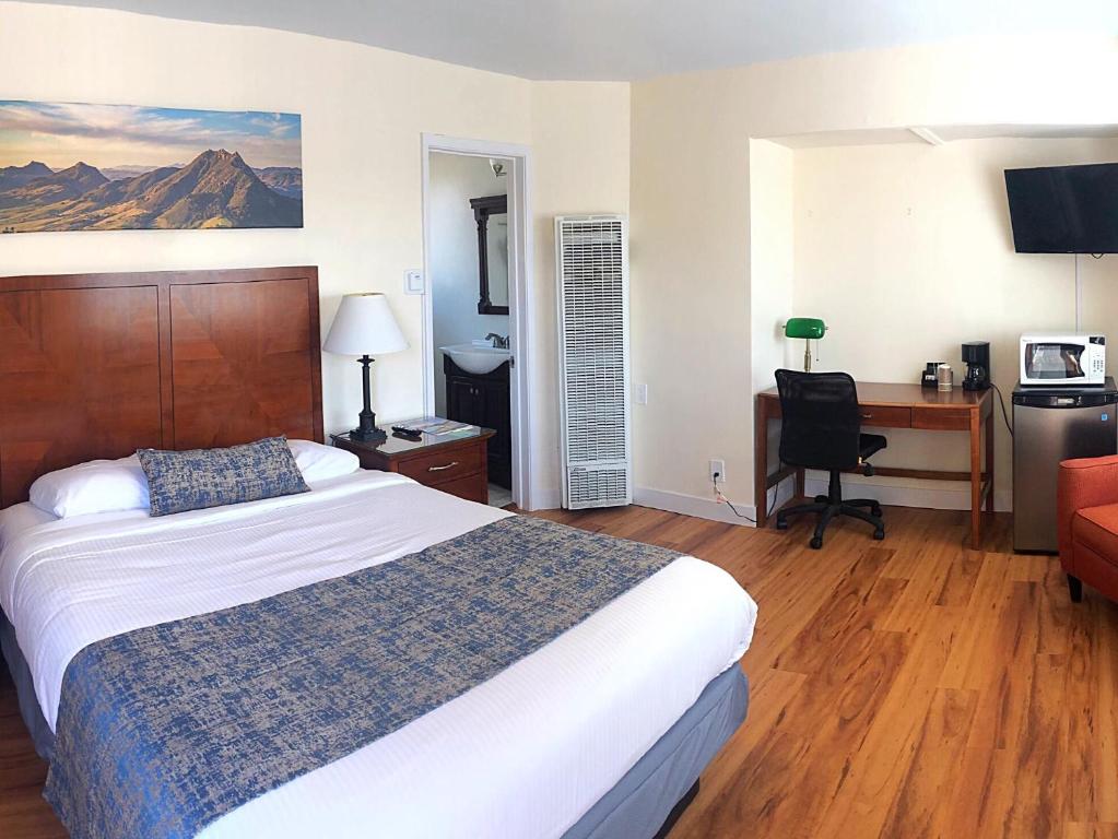 a hotel room with a bed and a desk with a computer at Sunbeam Motel in San Luis Obispo