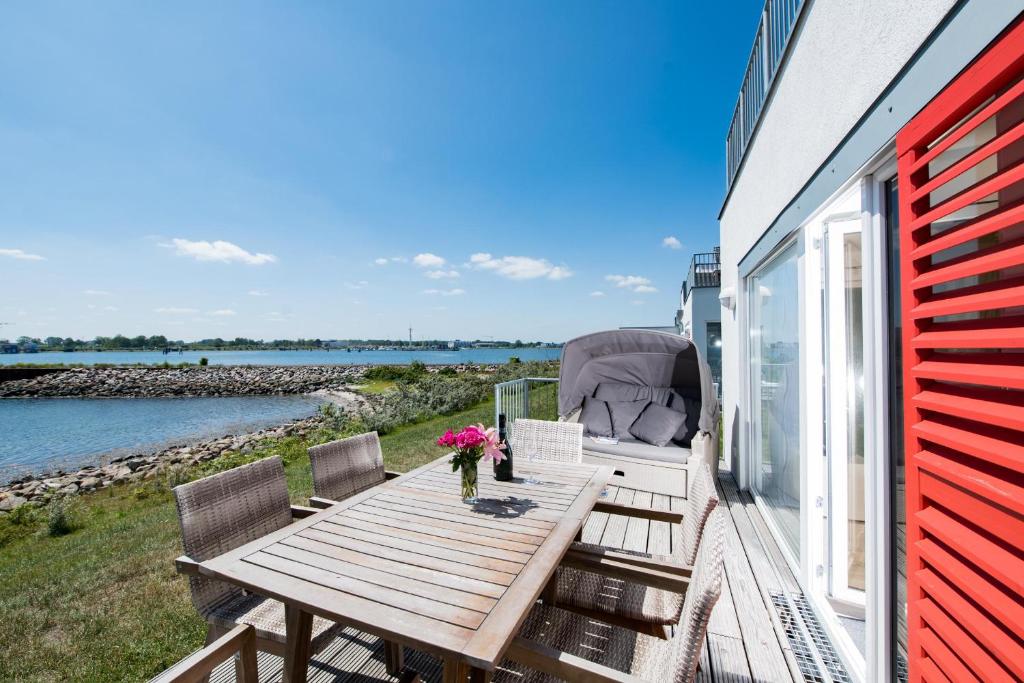 a deck with a table and chairs on a house at Marina 1 in Olpenitz
