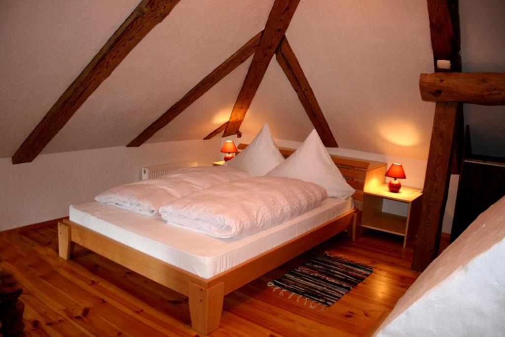 een bed met witte lakens en kussens in een kamer bij Goldingen in Kuldīga