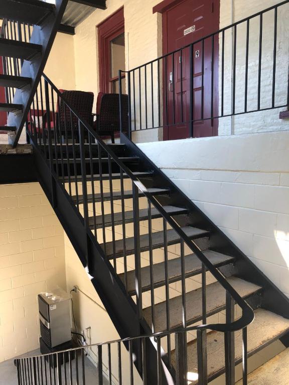 a black staircase in a building with a door at Baseball Town Motel in Cooperstown