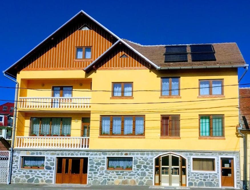 a yellow building with solar panels on top of it at Pensiunea Nelu & Klein in Sibiu