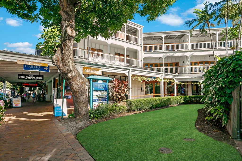 a large white building with a green lawn in front of it at Mantra on the Inlet in Port Douglas