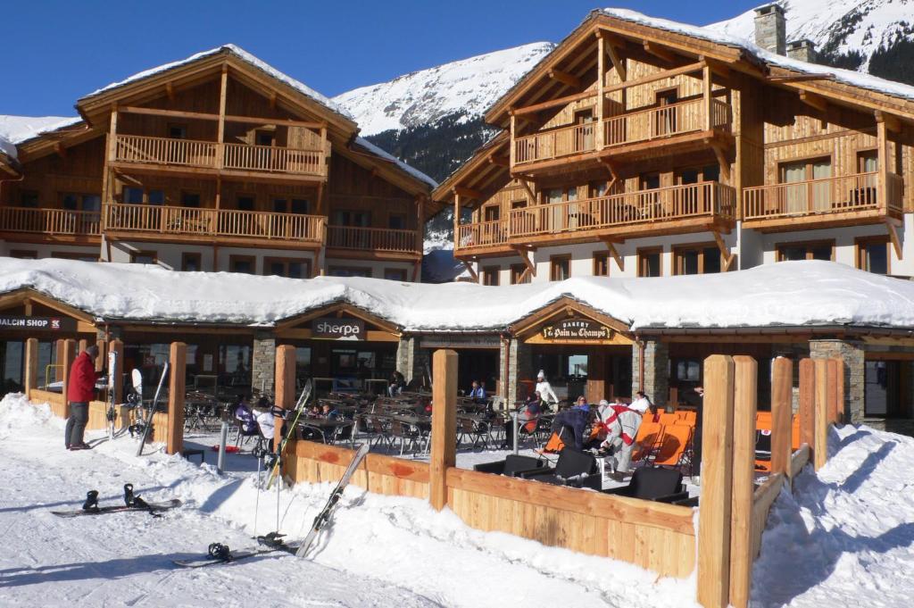 un lodge de ski dans les montagnes avec de la neige au sol dans l'établissement Résidence Le Critérium, à Lanslebourg-Mont-Cenis