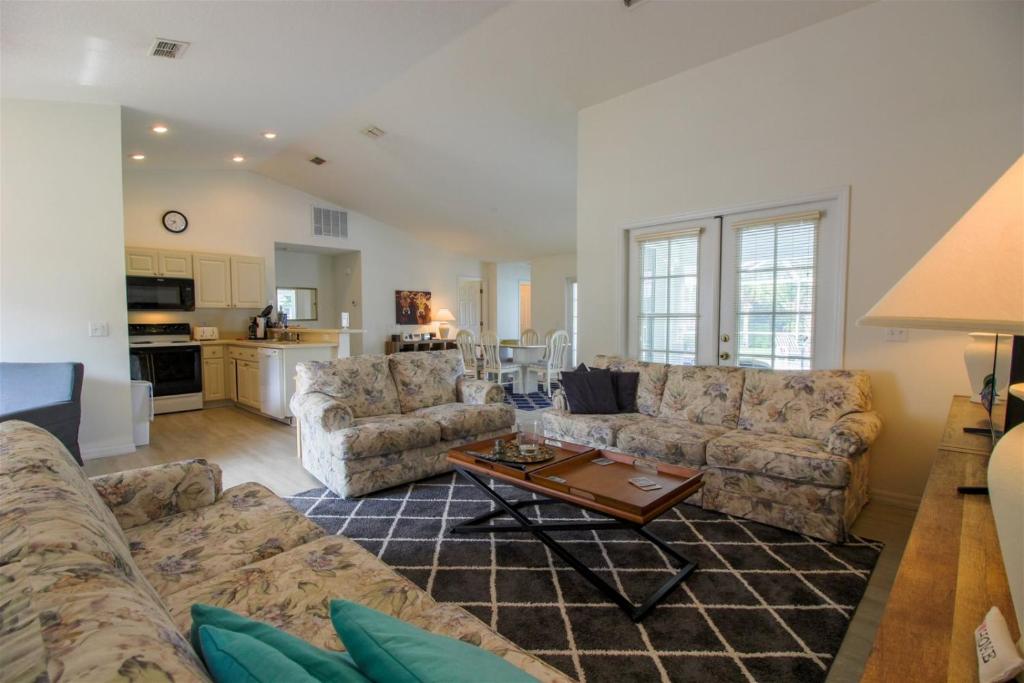 a living room with couches and a coffee table at Luxury 2BR-3BA Pool Villa and 20 Min to WEC- Ocala in Inverness