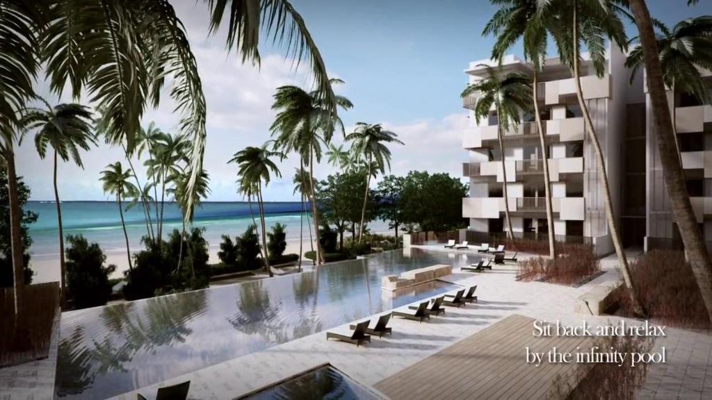 Blick auf ein Resort mit Palmen und den Strand in der Unterkunft By The Sea BeachFront Penang in Batu Feringgi