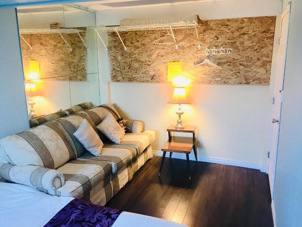 卡爾加里的住宿－卡爾加里明星舒適之家旅館，客厅配有沙发和桌子
