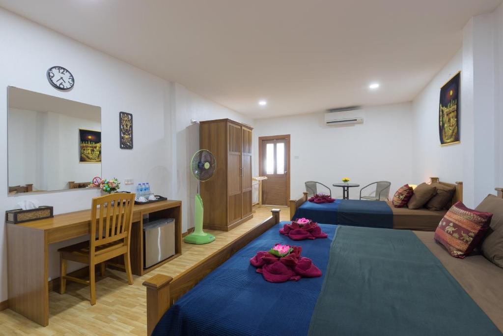 a living room with a couch and a table with flowers on it at Family Song Koh Lipe in Ko Lipe