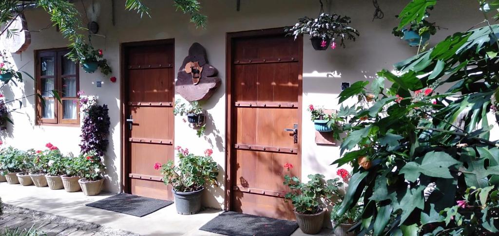 a house with two doors and potted plants on it at Lily Bank Cottage in Nuwara Eliya
