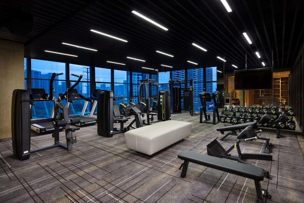 a gym with cardio equipment and a view of the city at Wyndham Grand Maoming in Maoming