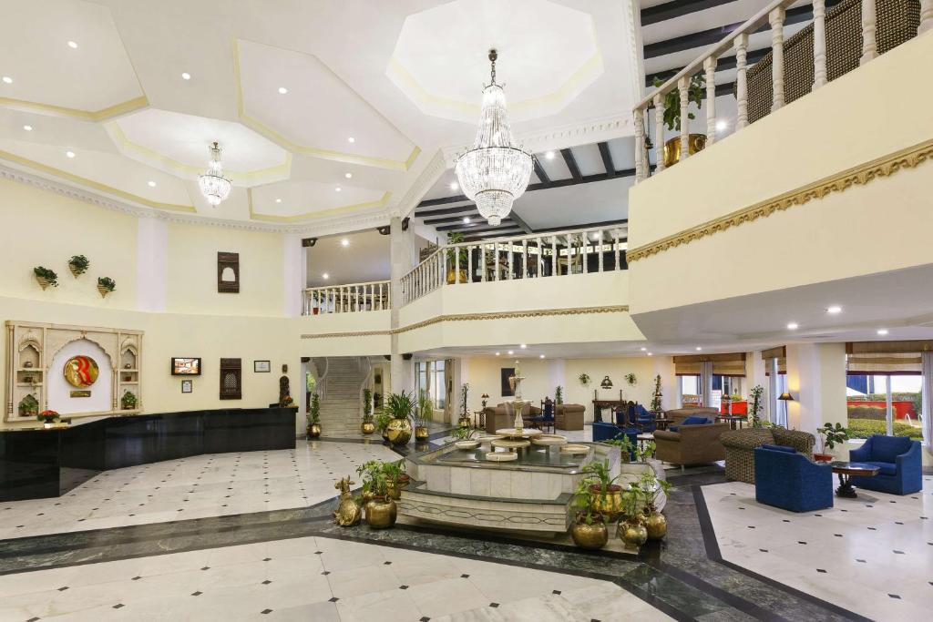 a lobby of a hotel with a reception desk and a large lobby at Ramada Khajuraho in Khajurāho