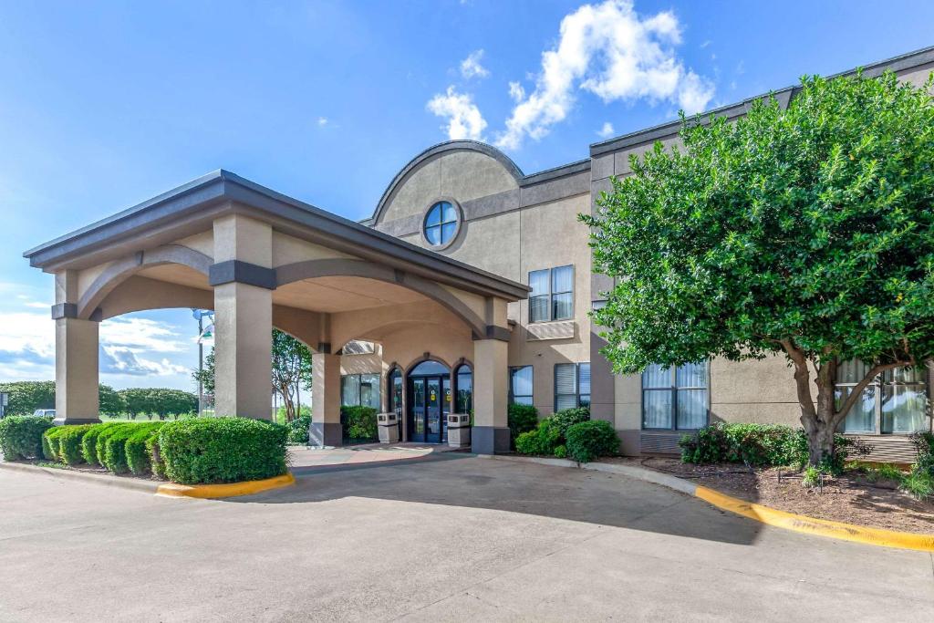 un edificio con un árbol delante de él en Quality Inn & Suites Durant, en Durant