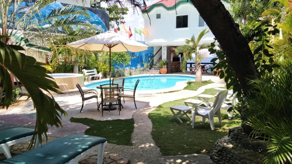 d'une terrasse avec une table et des chaises à côté de la piscine. dans l'établissement Love's Beach & Dive Resort, à Moalboal