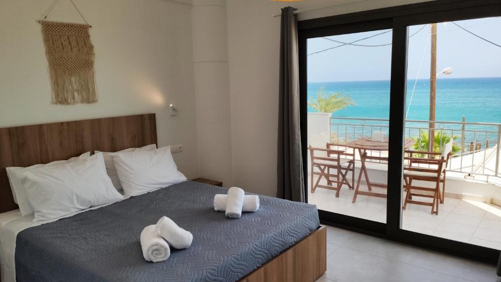 una camera con letto e vista sull'oceano di Ellie Apartments Stalida a Stalida