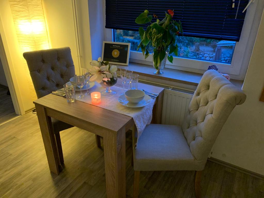 a dining room table with two chairs and a table with a candle at Lütt Hamburg in Geesthacht