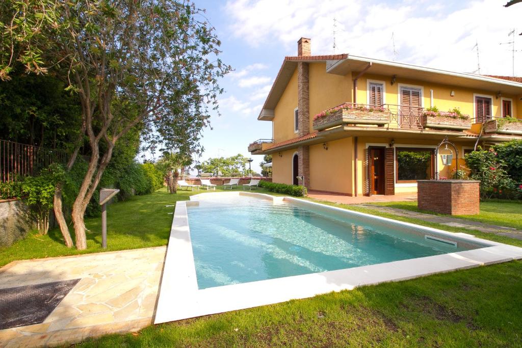 a swimming pool in front of a house at Etna Villa Alba Chiara in Trecastagni