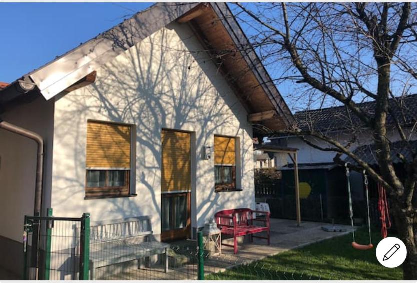 een wit huis met een rode bank ervoor bij Knusperhaus mit Garten in Salzburg