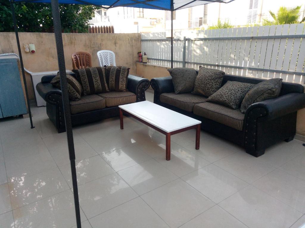 a patio with couches and a table and an umbrella at Sheffer in Ramat Gan