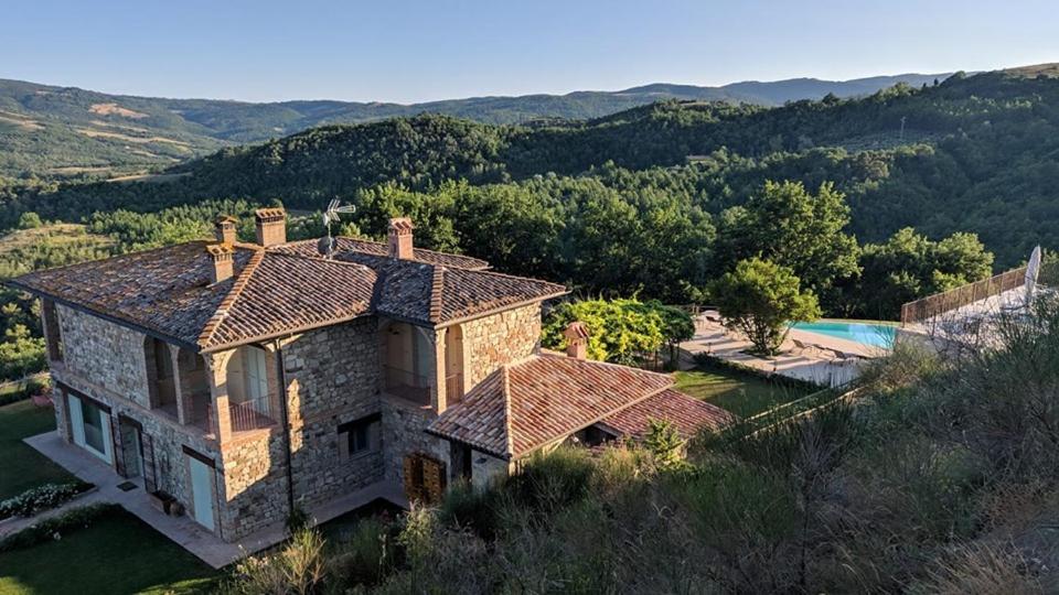 z góry widok na dom z basenem w obiekcie Agriturismo Fattoria di Monticello w mieście San Venanzo