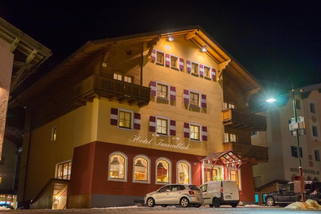 un edificio con coches aparcados delante de él por la noche en Hotel Tauernblick en Obertauern