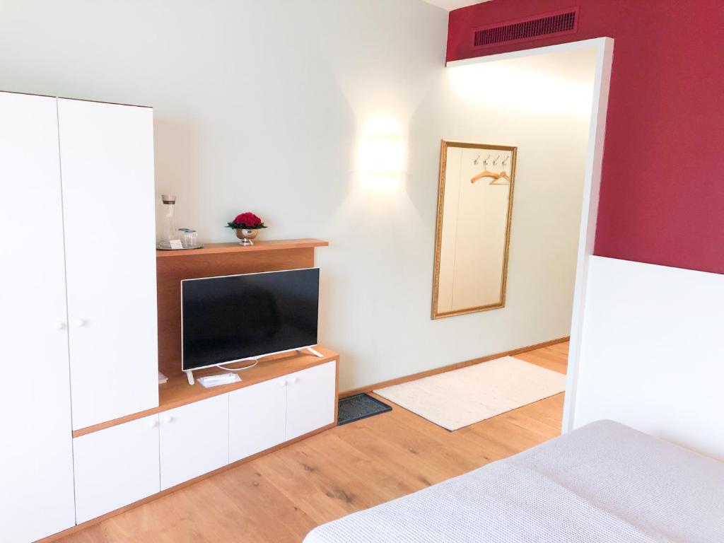 sypialnia z telewizorem, łóżkiem i lustrem w obiekcie Die Schmiede w mieście Ybbsitz