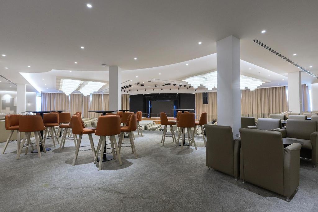 a dining room with tables and chairs in a building at Hipotels Barrosa Park in Chiclana de la Frontera