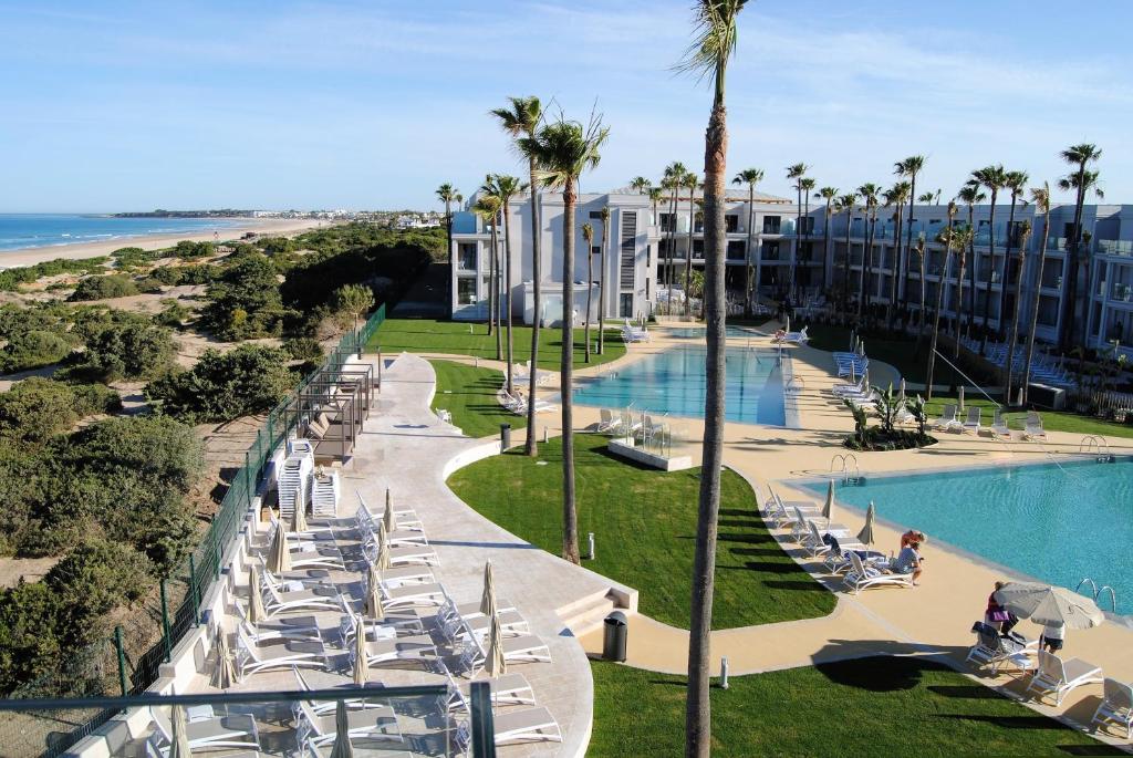 a view of a resort with a pool and palm trees at Hipotels Barrosa Park in Chiclana de la Frontera