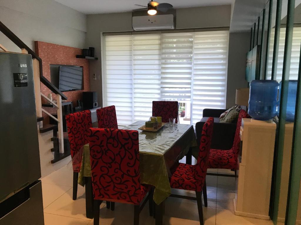 a dining room with a table and red chairs at Creys Condo 3 at Pico De Loro Cove in Nasugbu
