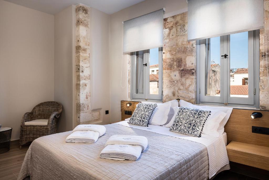 a bedroom with a bed with two towels on it at Aoria Estate Old Port in Chania Town