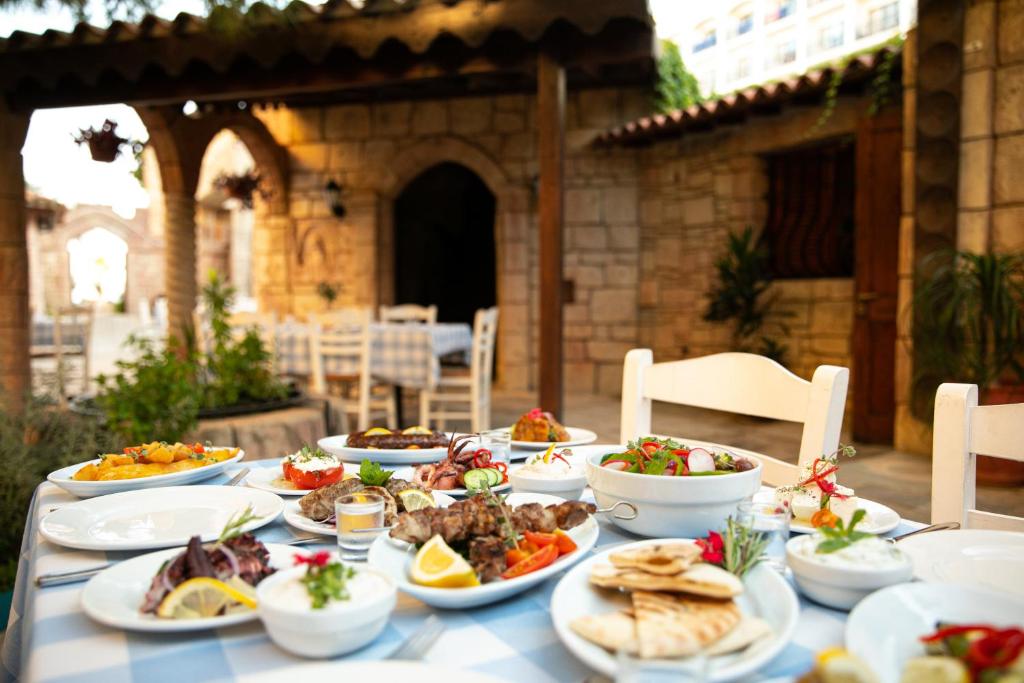 a table with plates of food on it at Golden Bay Beach Hotel in Larnaca