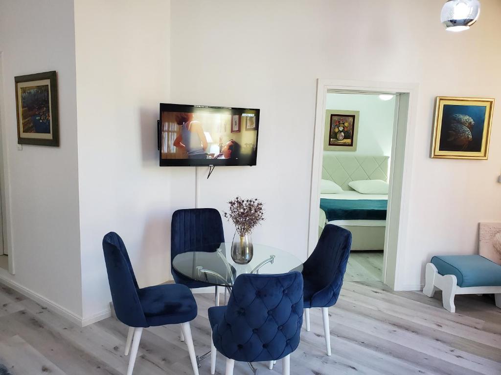 ブドヴァにあるMM Apartmentのダイニングルーム(テーブル、青い椅子付)
