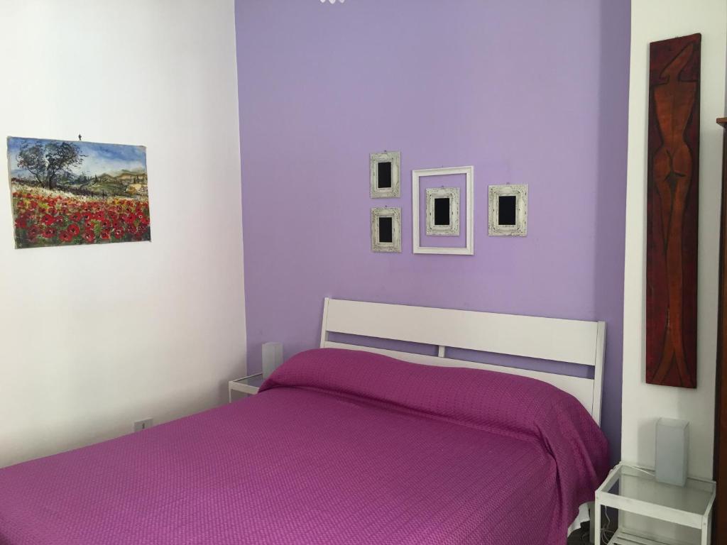 アグリジェントにあるAntonio's Houseの紫のシーツ付きのベッドが備わる紫のベッドルームです。