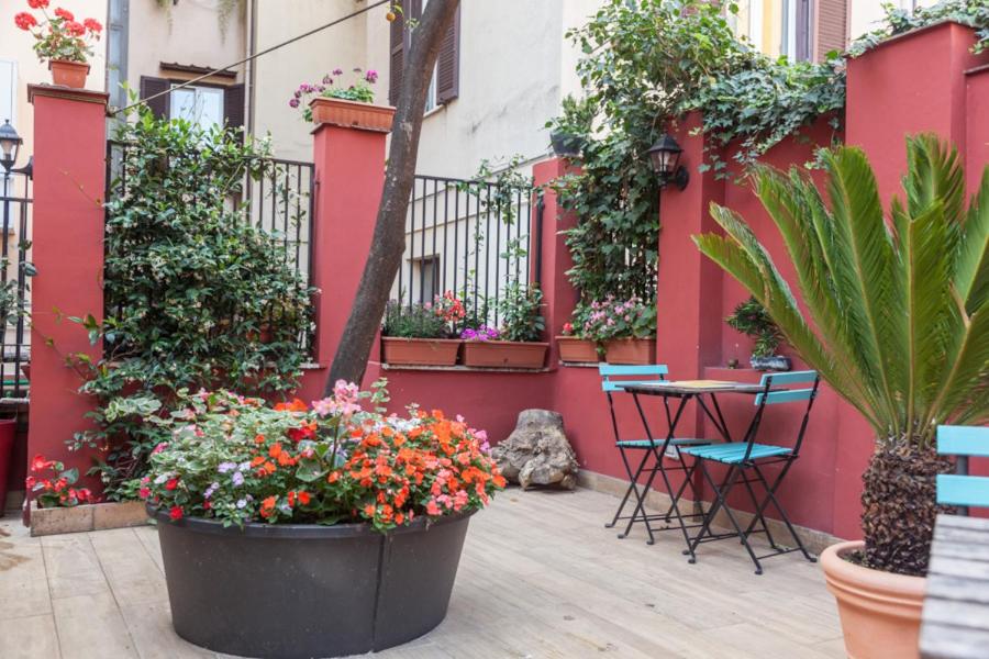 eine Terrasse mit Blumen, einem Tisch und Stühlen in der Unterkunft Monti Garden in Rom