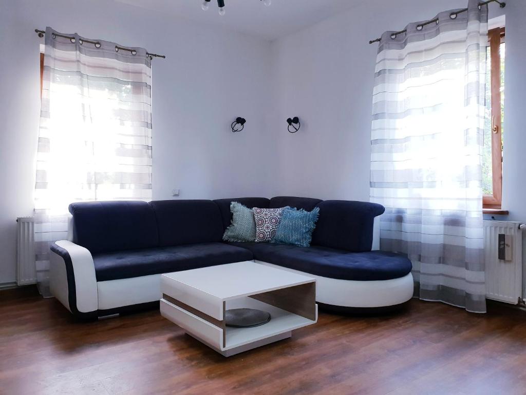 a living room with a blue couch and a table at Apartament Wałbrzych / Szczawno - Zdrój in Wałbrzych